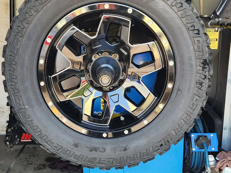 Close-up of an all-terrain tyre mounted on an alloy wheel in the workshop